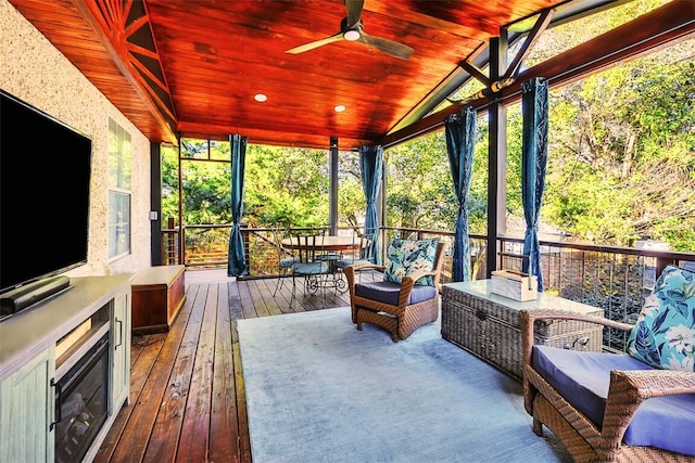 sunroom / solarium with wood ceiling, ceiling fan, and vaulted ceiling