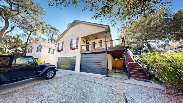 view of front of home featuring stairs, stucco siding, an attached garage, and driveway