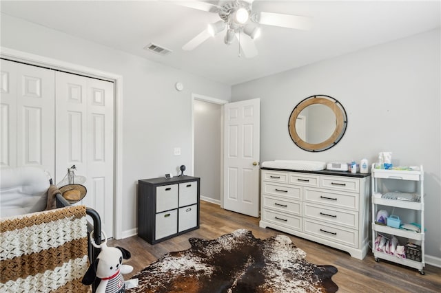 bedroom with a closet, a ceiling fan, visible vents, baseboards, and dark wood finished floors