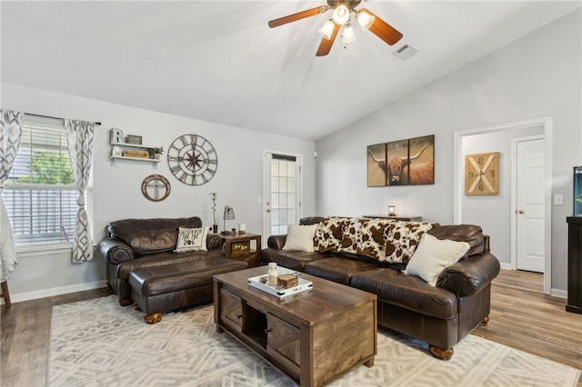 living room with a ceiling fan, visible vents, vaulted ceiling, and light wood-style floors