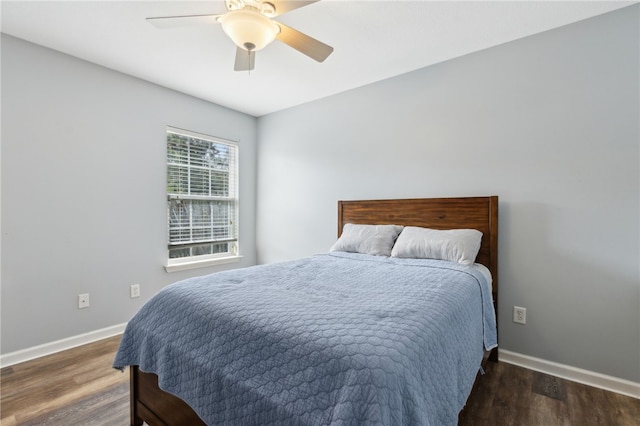 bedroom featuring baseboards, wood finished floors, and ceiling fan