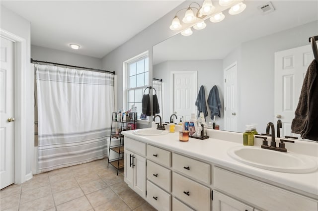 bathroom with double vanity, visible vents, tile patterned floors, and a sink