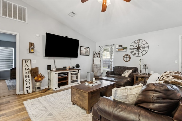 living room with visible vents, ceiling fan, light wood finished floors, and lofted ceiling