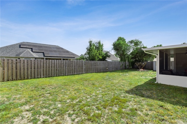 view of yard featuring a fenced backyard and a sunroom
