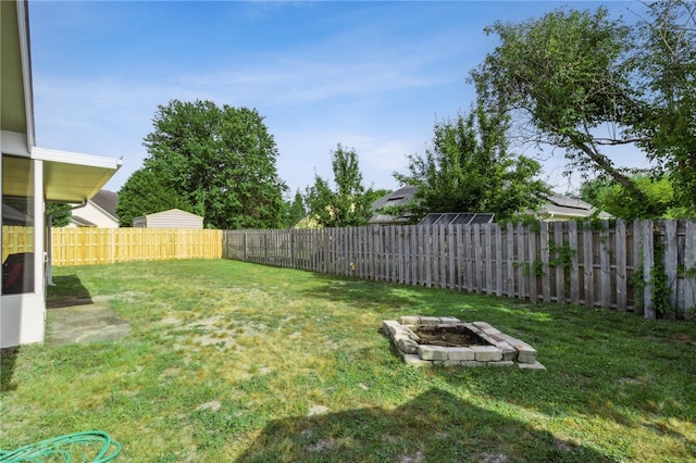 view of yard with a fire pit and a fenced backyard