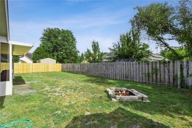 view of yard with a fire pit and a fenced backyard