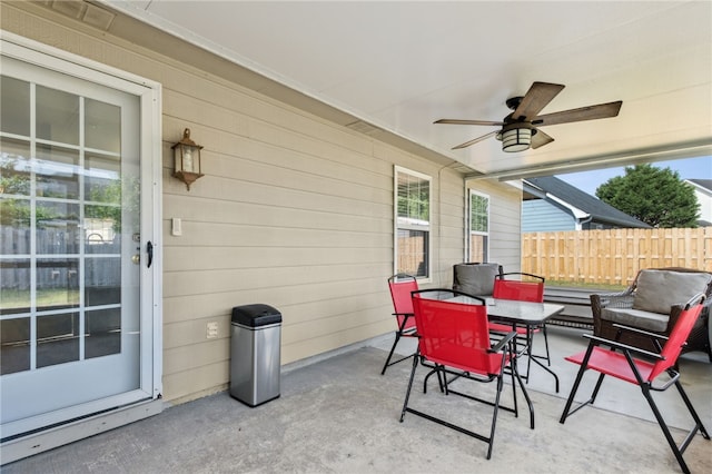 view of patio featuring fence, outdoor dining space, and ceiling fan