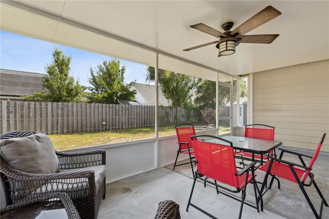 sunroom with a wealth of natural light, a ceiling fan, and outdoor dining area