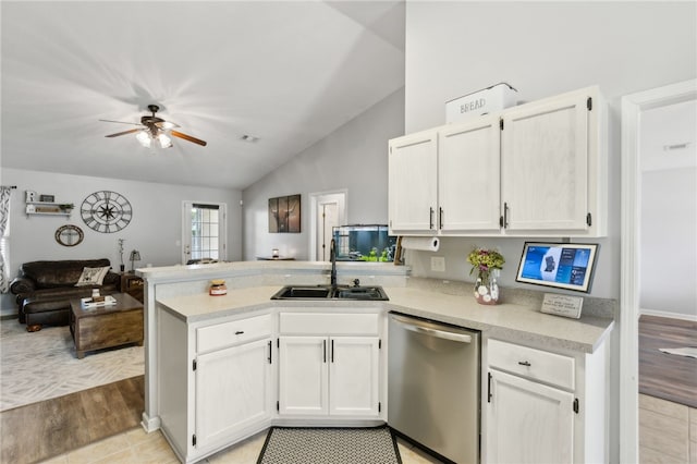 kitchen featuring a sink, vaulted ceiling, a peninsula, dishwasher, and white cabinets