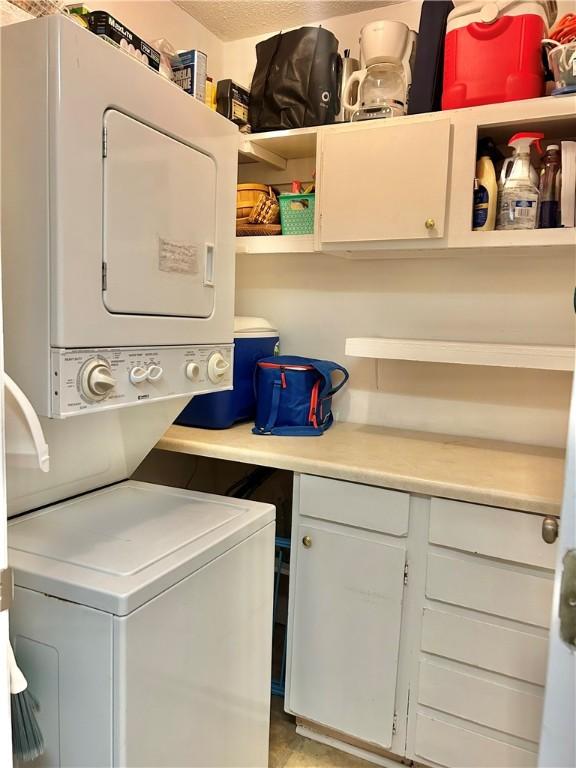 850 Mallery St Unit 4S, Saint Simons Island, GA 31522 - washroom featuring stacked washer / dryer and cabinet space