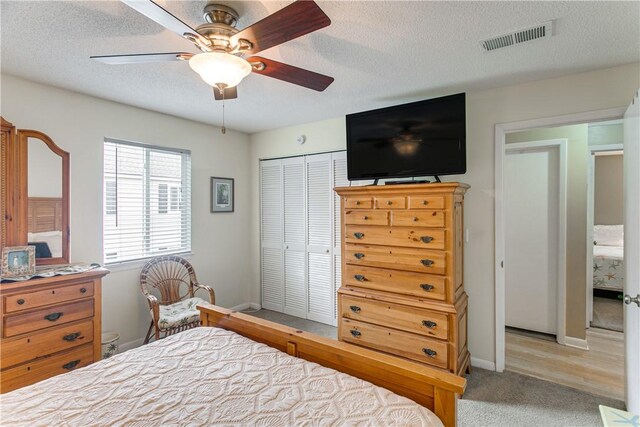 850 Mallery St Unit 4S, Saint Simons Island, GA 31522 - bedroom featuring a textured ceiling, a closet, baseboards, light colored carpet, and a ceiling fan