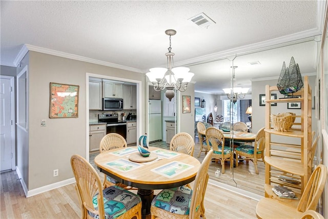 850 Mallery St Unit 4S, Saint Simons Island, GA 31522 - dining room featuring a chandelier, ornamental molding, light wood-style flooring, a textured ceiling, and baseboards