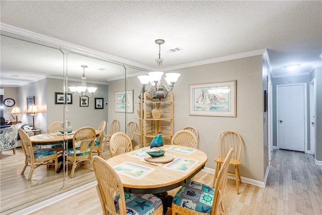 850 Mallery St Unit 4S, Saint Simons Island, GA 31522 - dining area featuring a chandelier, light wood-type flooring, crown molding, a textured ceiling, and baseboards
