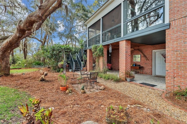 view of yard with a sunroom, stairs, and a patio