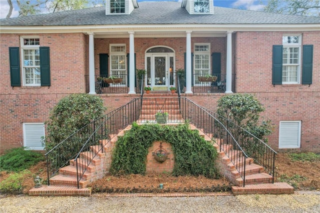 view of front of house with stairs and brick siding