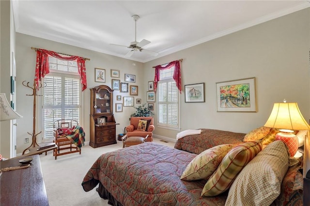 carpeted bedroom featuring ceiling fan, multiple windows, baseboards, and crown molding