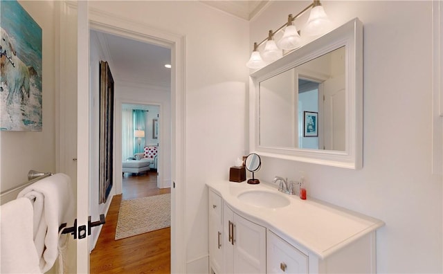 bathroom featuring wood-type flooring, vanity, and crown molding