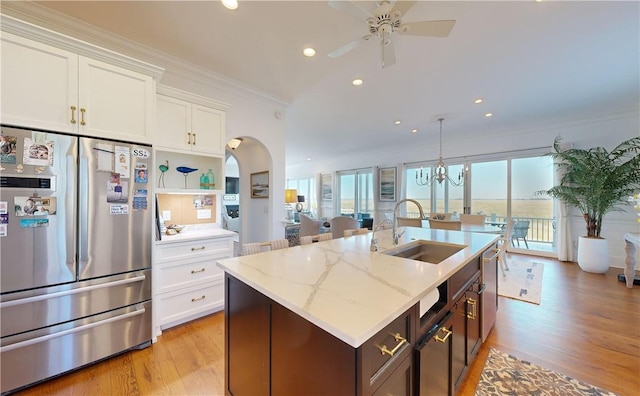 kitchen featuring light wood-type flooring, stainless steel appliances, white cabinetry, and sink