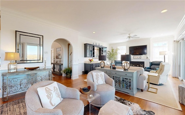 living room with dark hardwood / wood-style flooring, ornamental molding, and a wealth of natural light