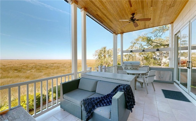 sunroom / solarium featuring a rural view, ceiling fan, and wood ceiling