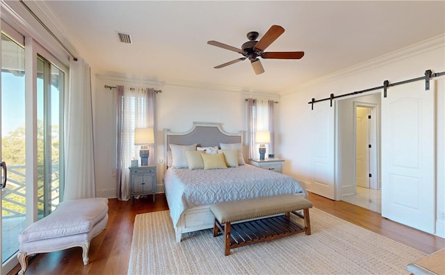 941 Champney, Saint Simons Island, GA 31522 - bedroom with a barn door, crown molding, wood finished floors, and a ceiling fan