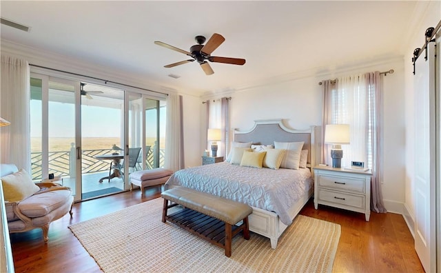 bedroom featuring access to exterior, light hardwood / wood-style flooring, and multiple windows