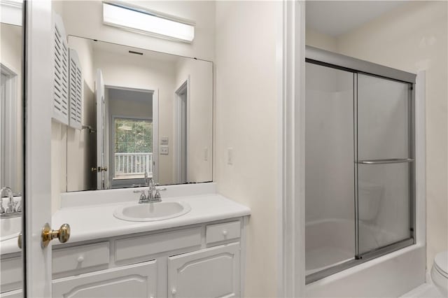 662 N Golf Villas Dr, Saint Simons Island, GA 31522 - bathroom with vanity, toilet, and bath / shower combo with glass door