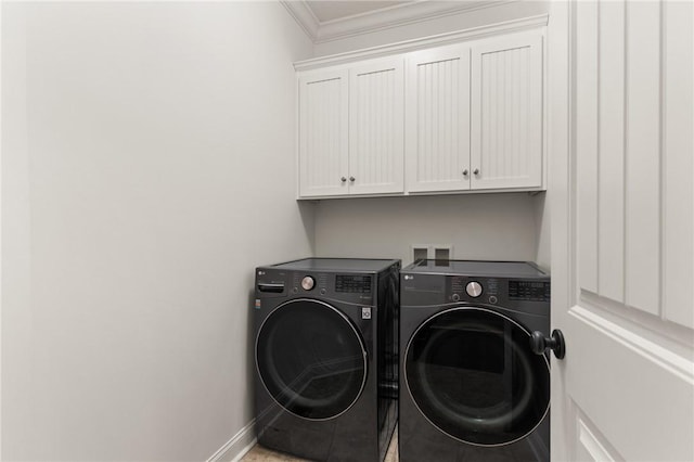 clothes washing area with cabinet space, independent washer and dryer, crown molding, and baseboards