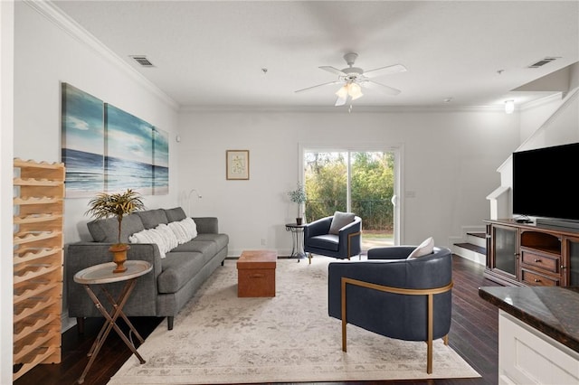 living area featuring visible vents, crown molding, ceiling fan, dark wood finished floors, and stairs