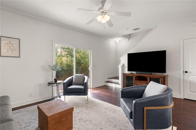 living area featuring visible vents, baseboards, wood finished floors, and ornamental molding