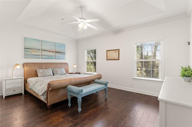 bedroom featuring visible vents, a raised ceiling, ornamental molding, baseboards, and dark wood-style flooring