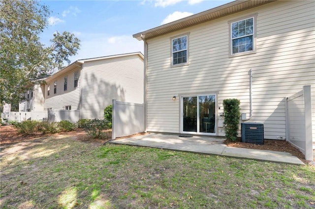 rear view of property featuring a patio area, cooling unit, a yard, and fence