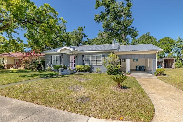 single story home with metal roof, concrete driveway, an attached carport, and a front yard