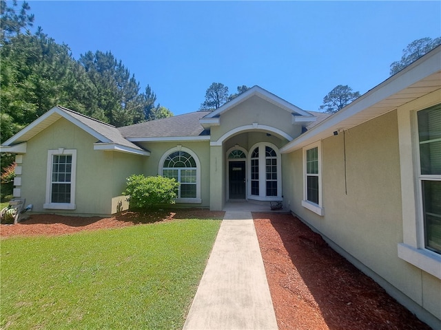 1002 Baltimore Ave, Waycross, GA 31501 - doorway to property with stucco siding, a lawn, and roof with shingles