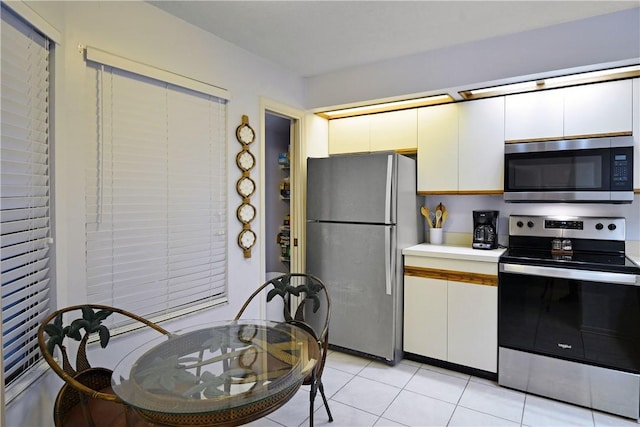 874 Wimbledon Dr, Saint Simons Island, GA 31522 - kitchen with appliances with stainless steel finishes, white cabinets, light countertops, and light tile patterned floors