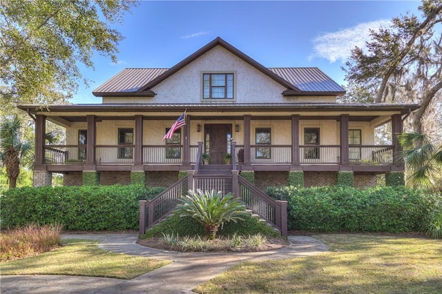 country-style home featuring brick siding, stucco siding, and a porch