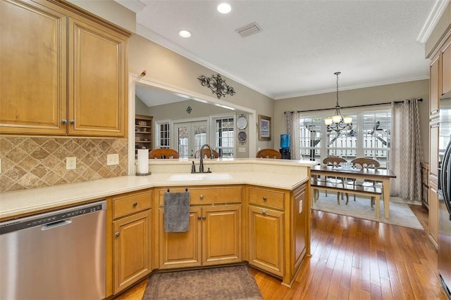 kitchen featuring a sink, plenty of natural light, a peninsula, and dishwasher