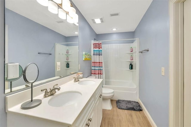 bathroom featuring wood finished floors, a sink, visible vents, and shower / tub combo with curtain