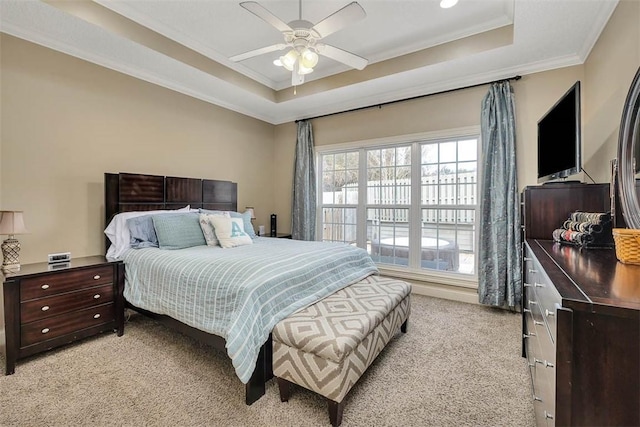 bedroom featuring light carpet, a tray ceiling, a ceiling fan, and crown molding