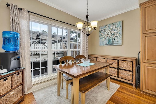 dining space featuring a chandelier, crown molding, and light wood-style flooring