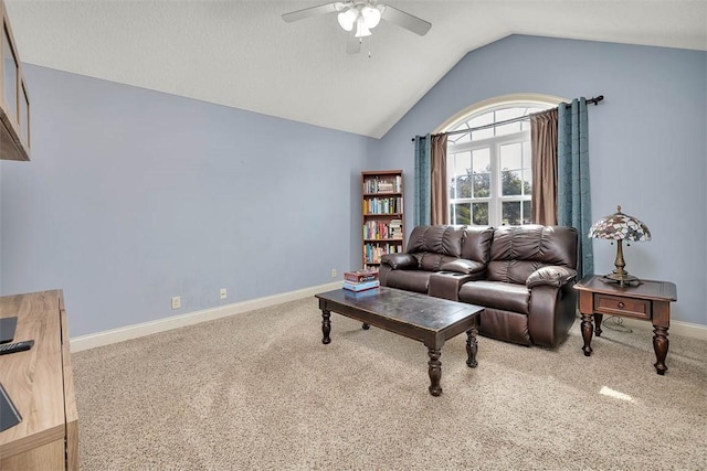 carpeted living area featuring baseboards, vaulted ceiling, and a ceiling fan