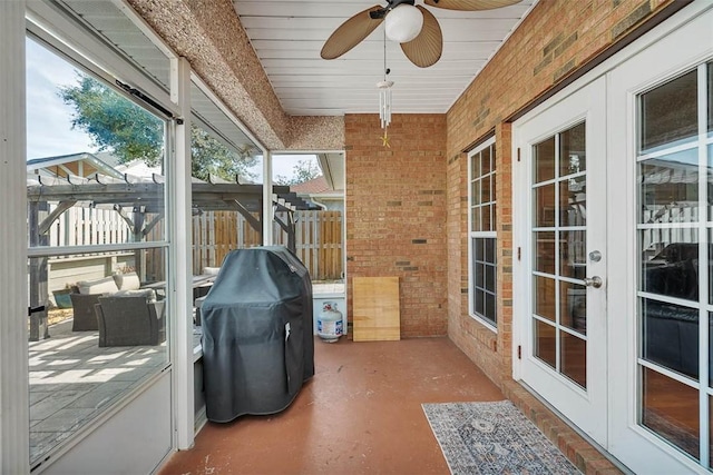 sunroom with a ceiling fan and french doors