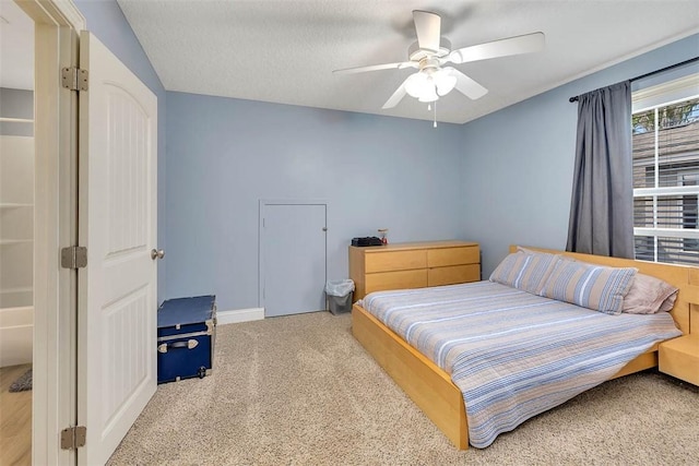 carpeted bedroom with a ceiling fan, a textured ceiling, and baseboards