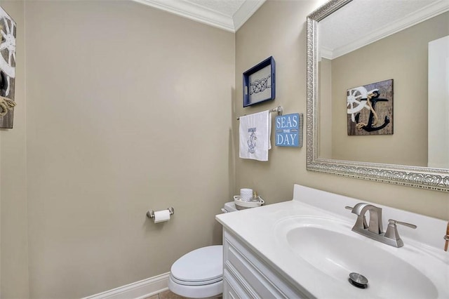 bathroom with baseboards, crown molding, vanity, and toilet