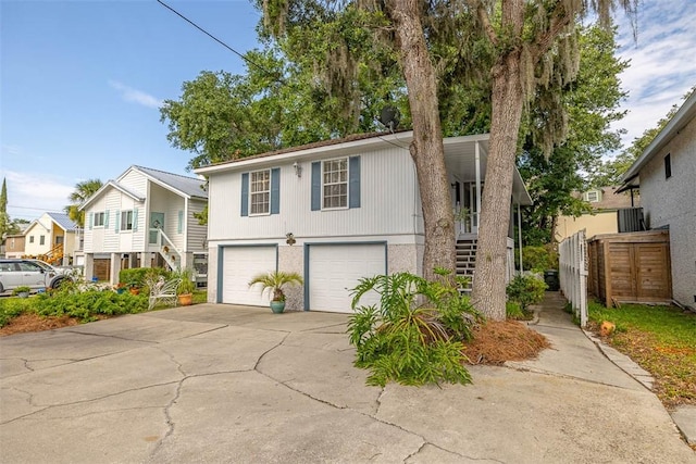 239 Georgia St, Saint Simons Island, GA 31522 - view of front of property with stairway, an attached garage, driveway, and a porch