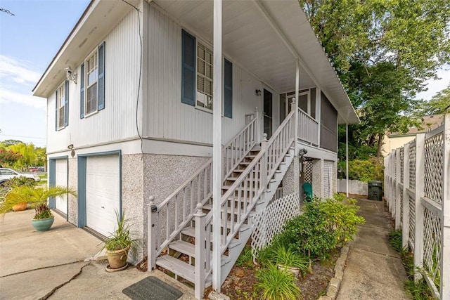 239 Georgia St, Saint Simons Island, GA 31522 - view of front facade with concrete driveway, stairs, a garage, and a porch