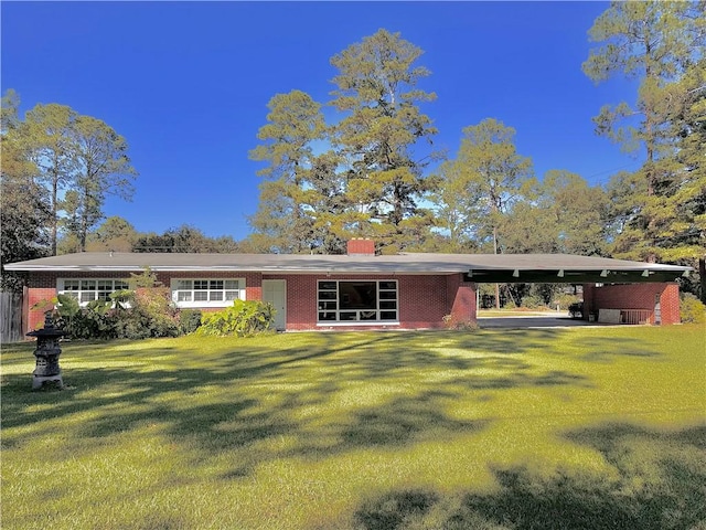 rear view of property featuring a carport and a lawn