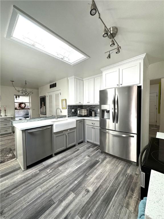 kitchen featuring gray cabinetry, white cabinetry, sink, and stainless steel appliances