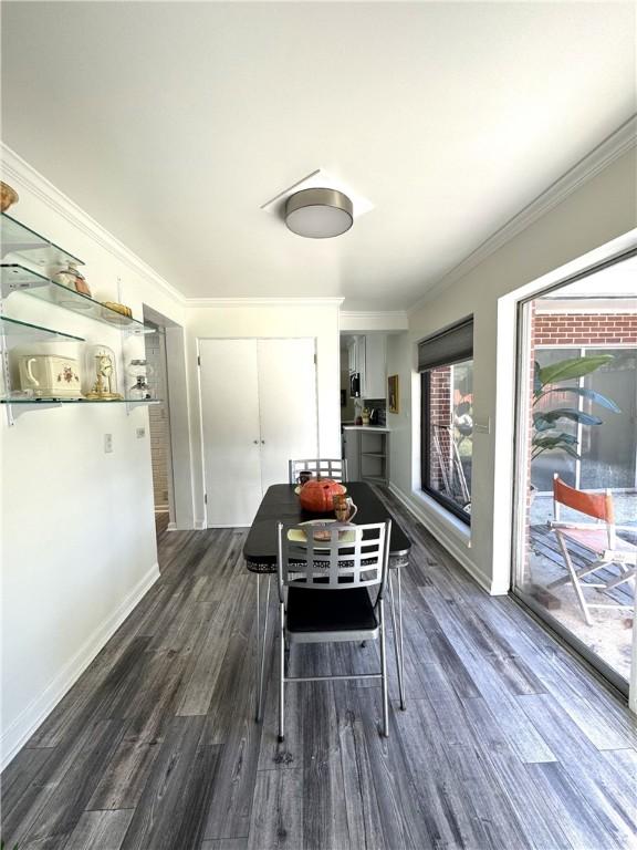 dining room with dark hardwood / wood-style flooring and ornamental molding