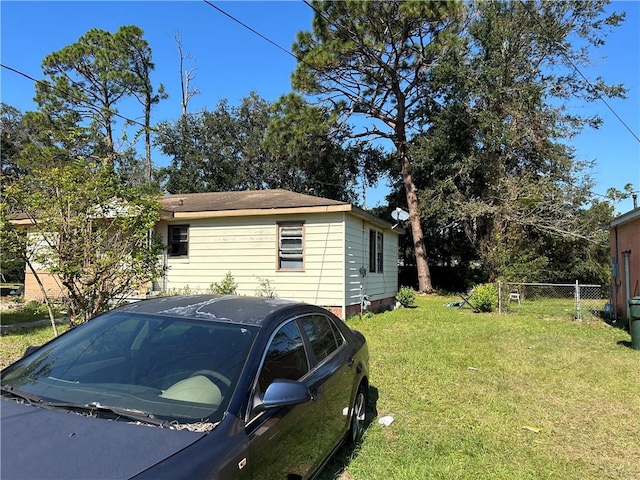 view of side of home with a yard